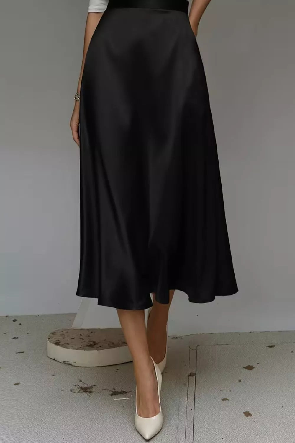 Black satin A-line midi skirt with side pockets, smooth panels and tapered midi hem