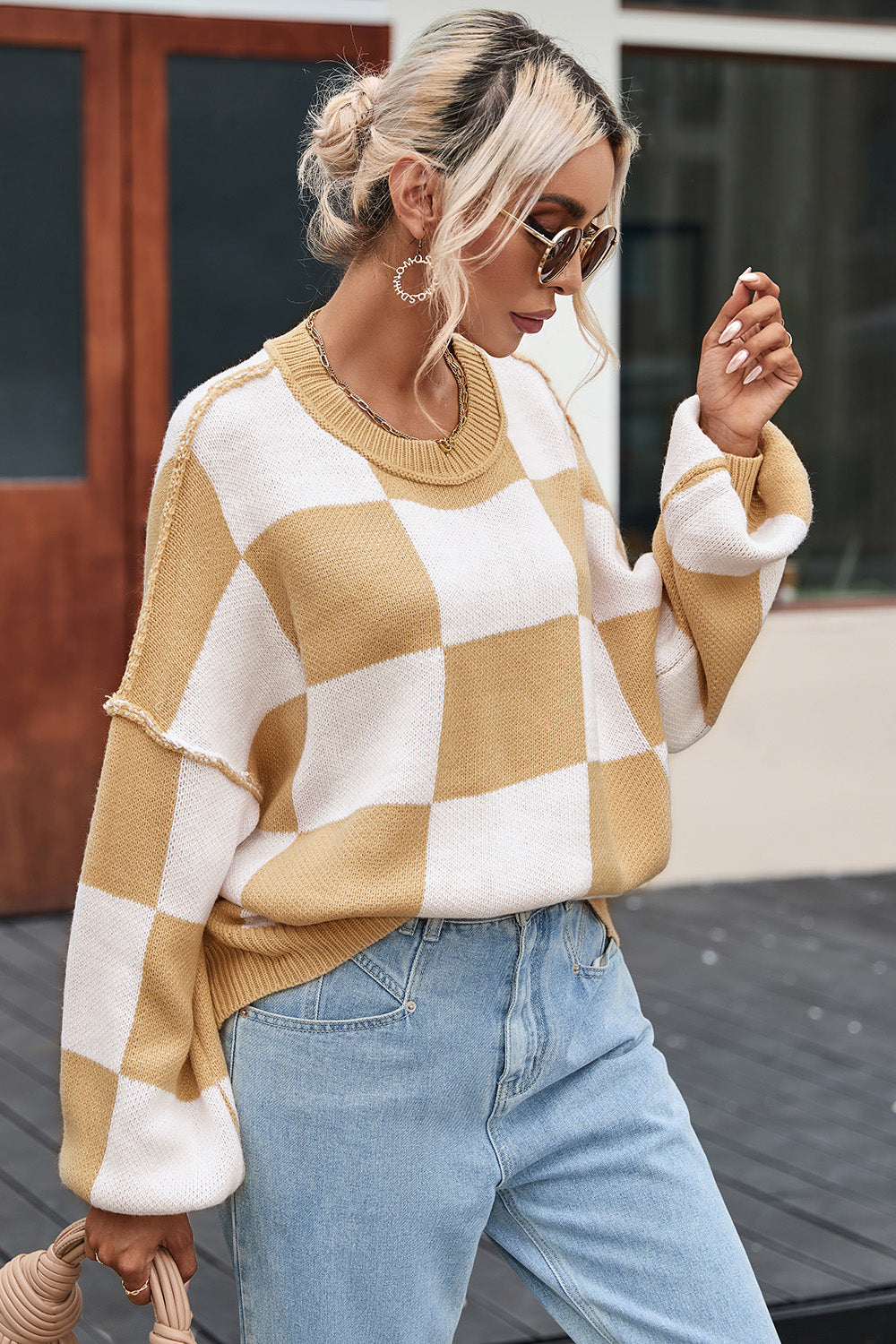 Tan and white checkered knit sweater with ribbed hem and drop-shoulder silhouette
