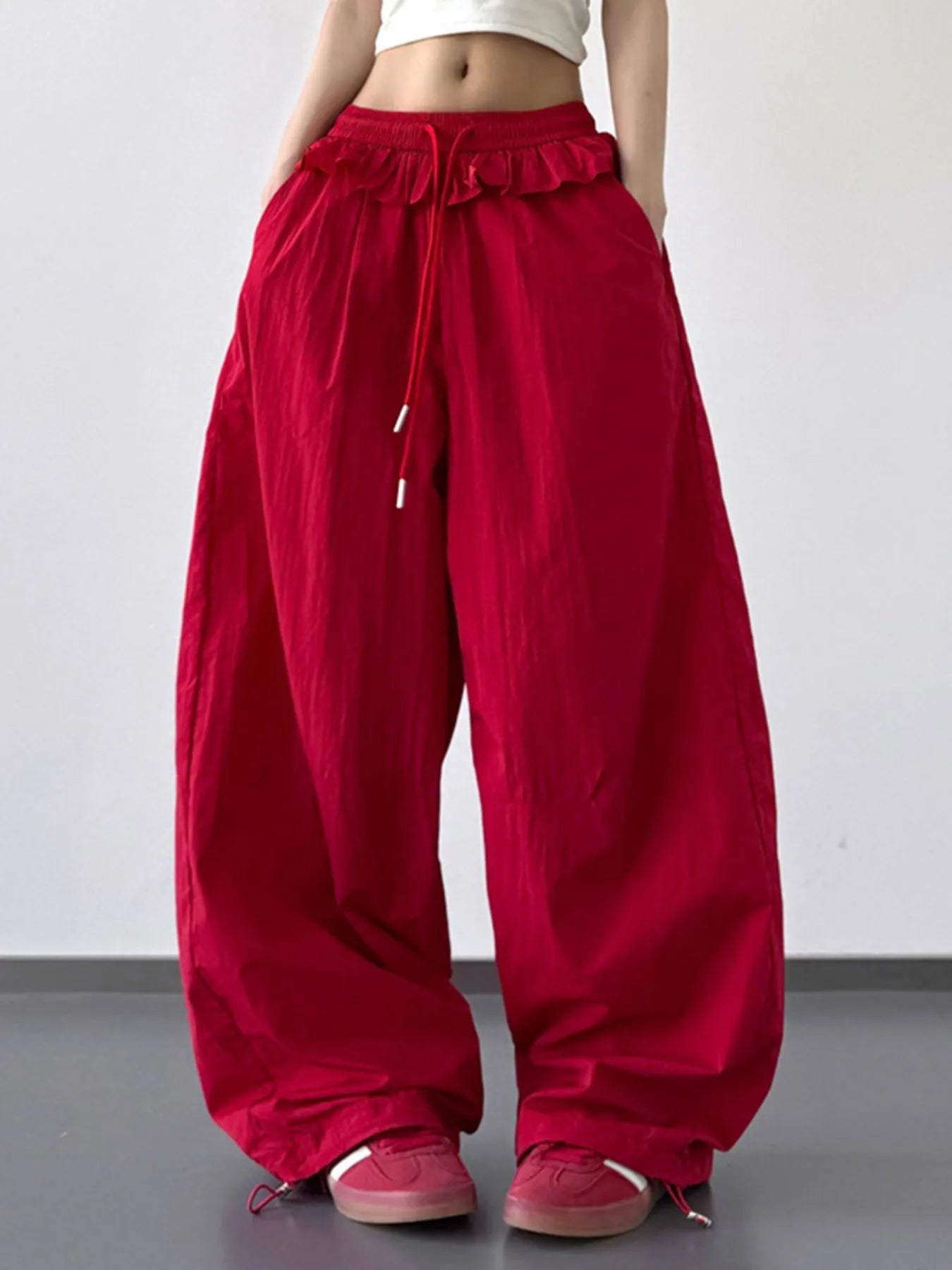 Red drawstring wide-leg pants with ruffled waistband and full, relaxed fit