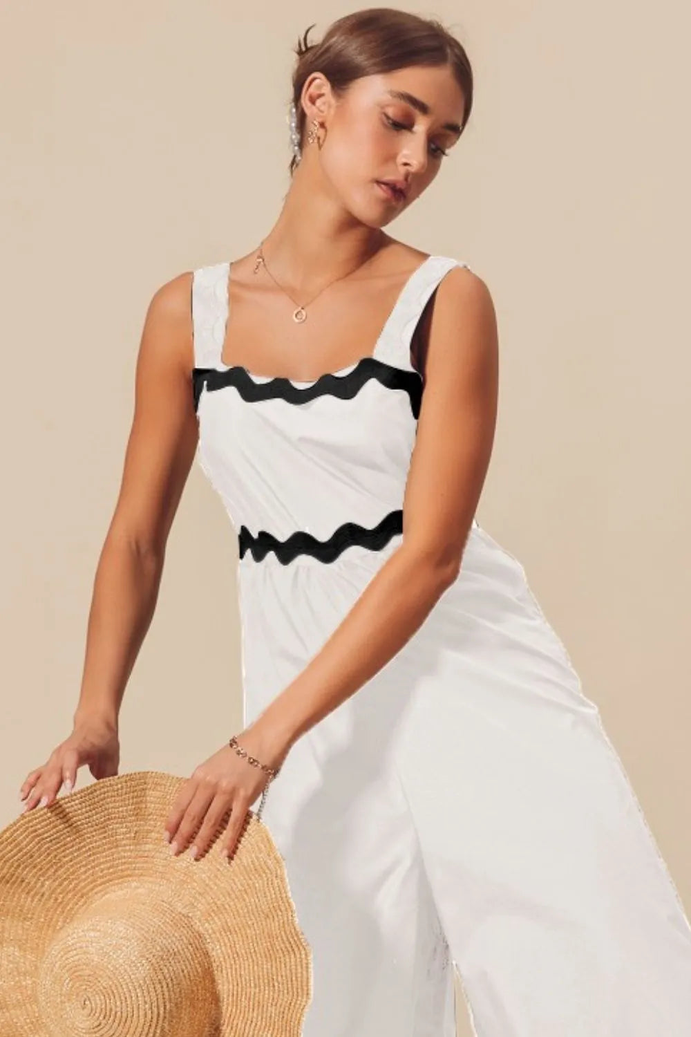Ivory wide-leg jumpsuit with black scalloped ric rac trim across bodice and hem.