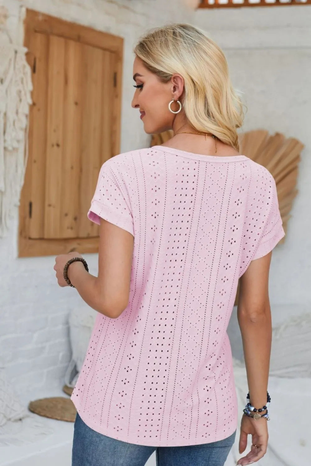Eyelet round-neck rolled short-sleeve T-shirt in blush pink, rear view with vertical cutouts