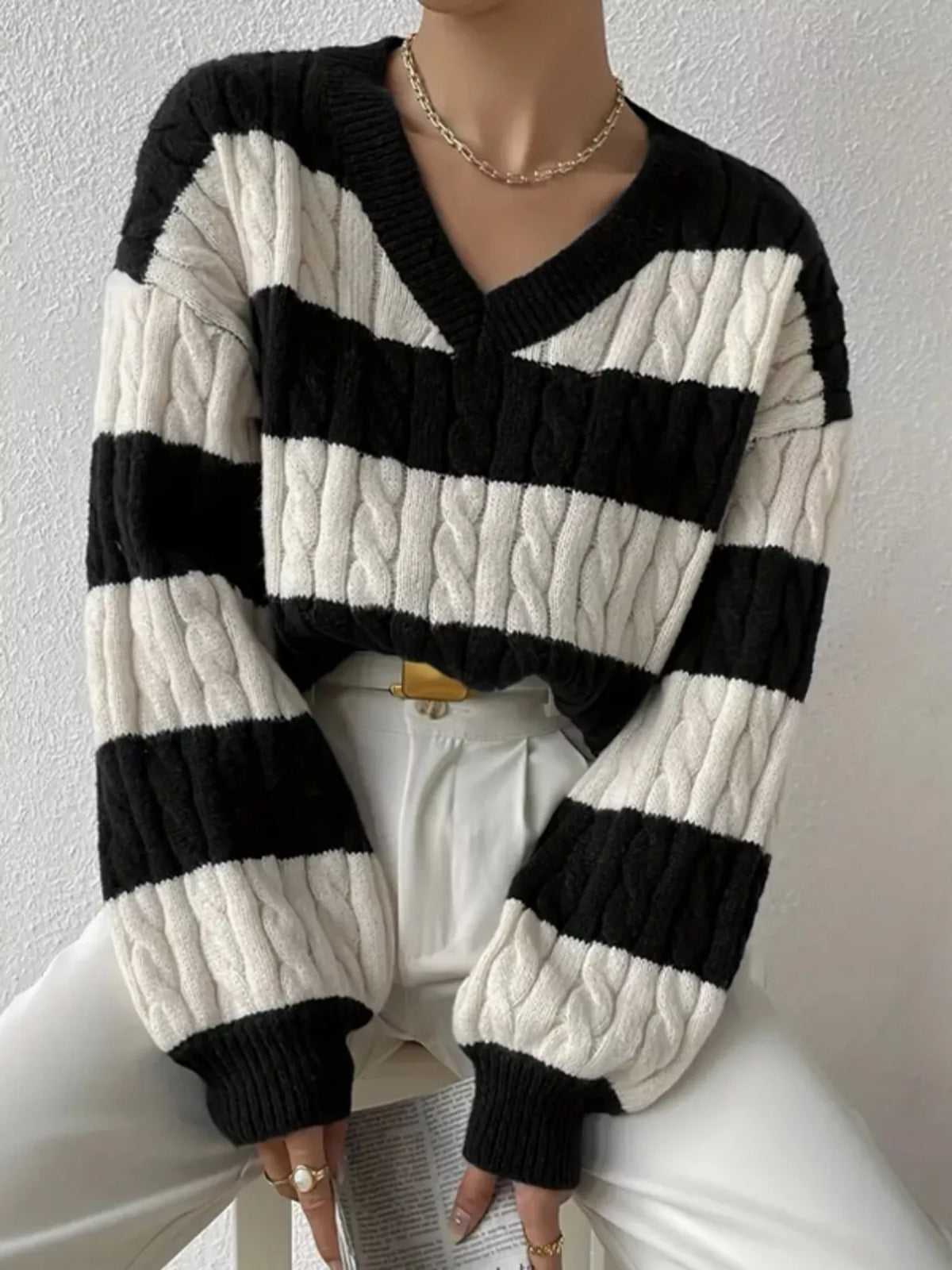 Black and off-white striped cable knit V-neck sweater with long ribbed sleeves