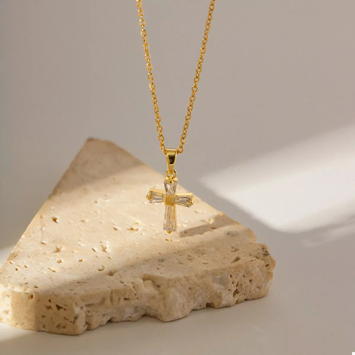 Gold-plated zircon cross pendant necklace with clear stones on a gold chain