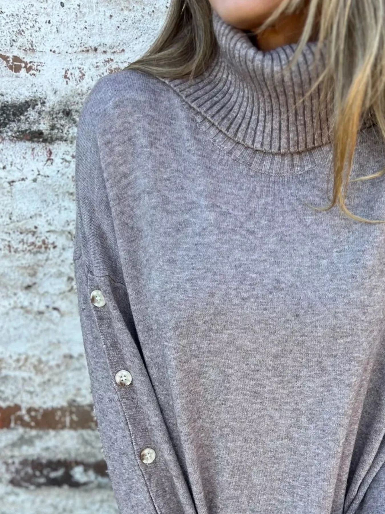 Dark gray turtleneck sweater with ribbed knit and buttoned sleeve cuffs