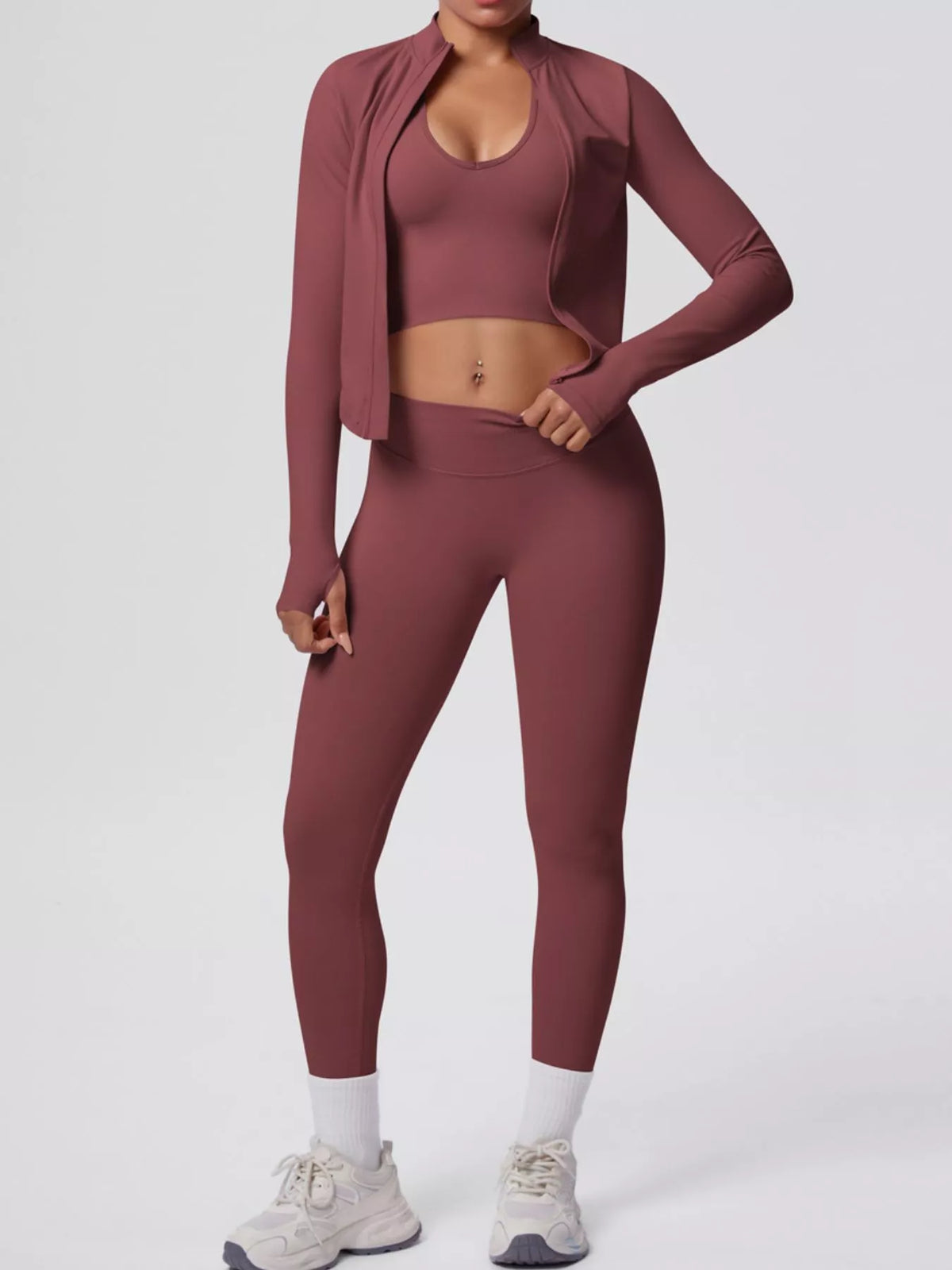 Rust three-piece workout set with open jacket, sports bra and leggings
