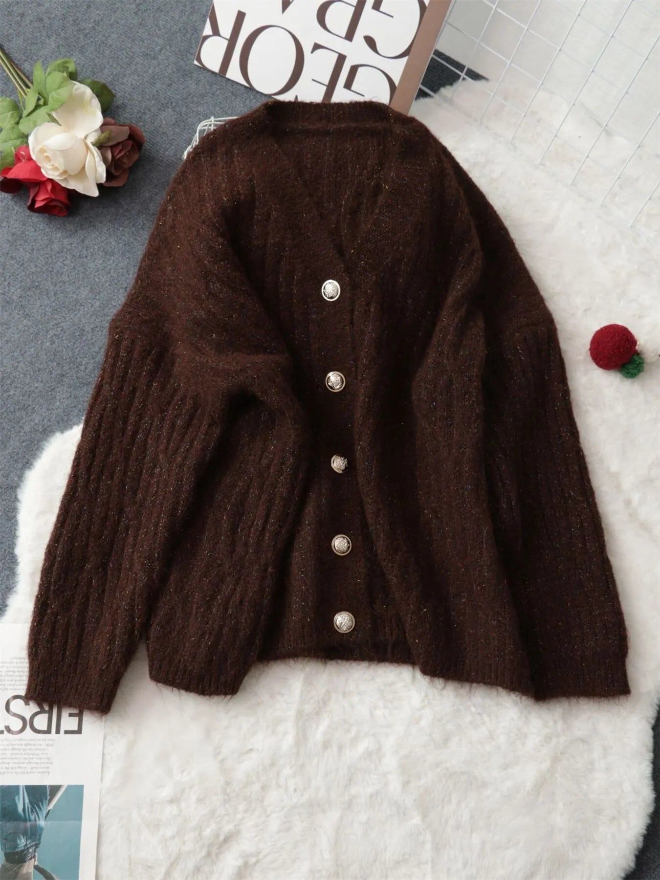 Brown cable-knit cardigan back view with small round button at top