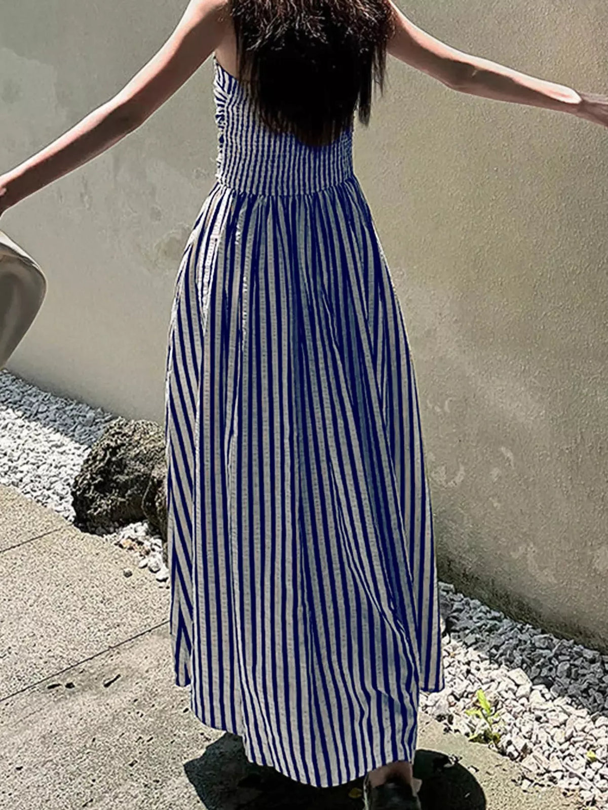 Sleeveless ruched maxi dress in blue-and-white vertical stripes with flowing skirt