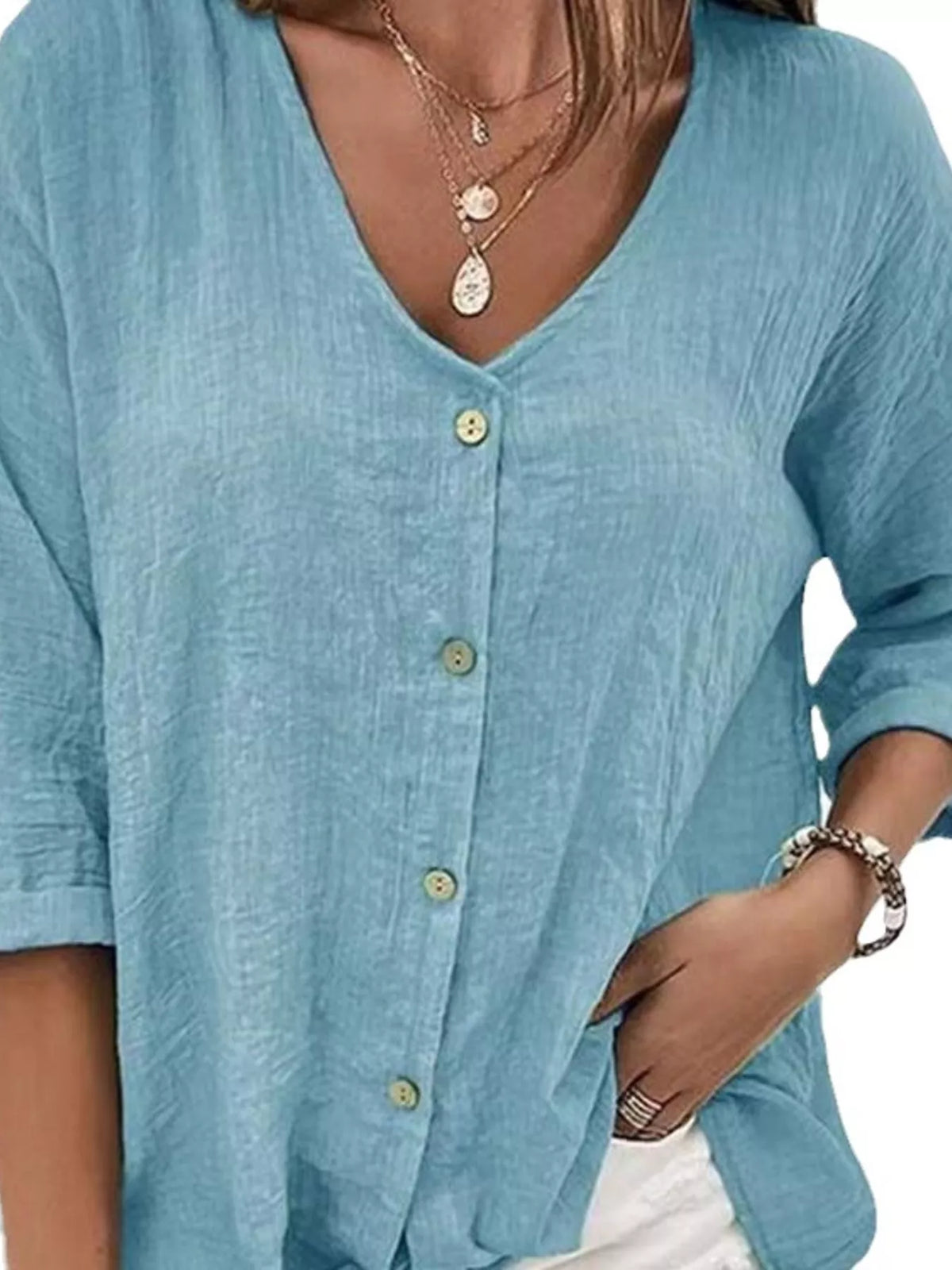 Blue V-neck blouse with button placket and three-quarter sleeves, relaxed drape
