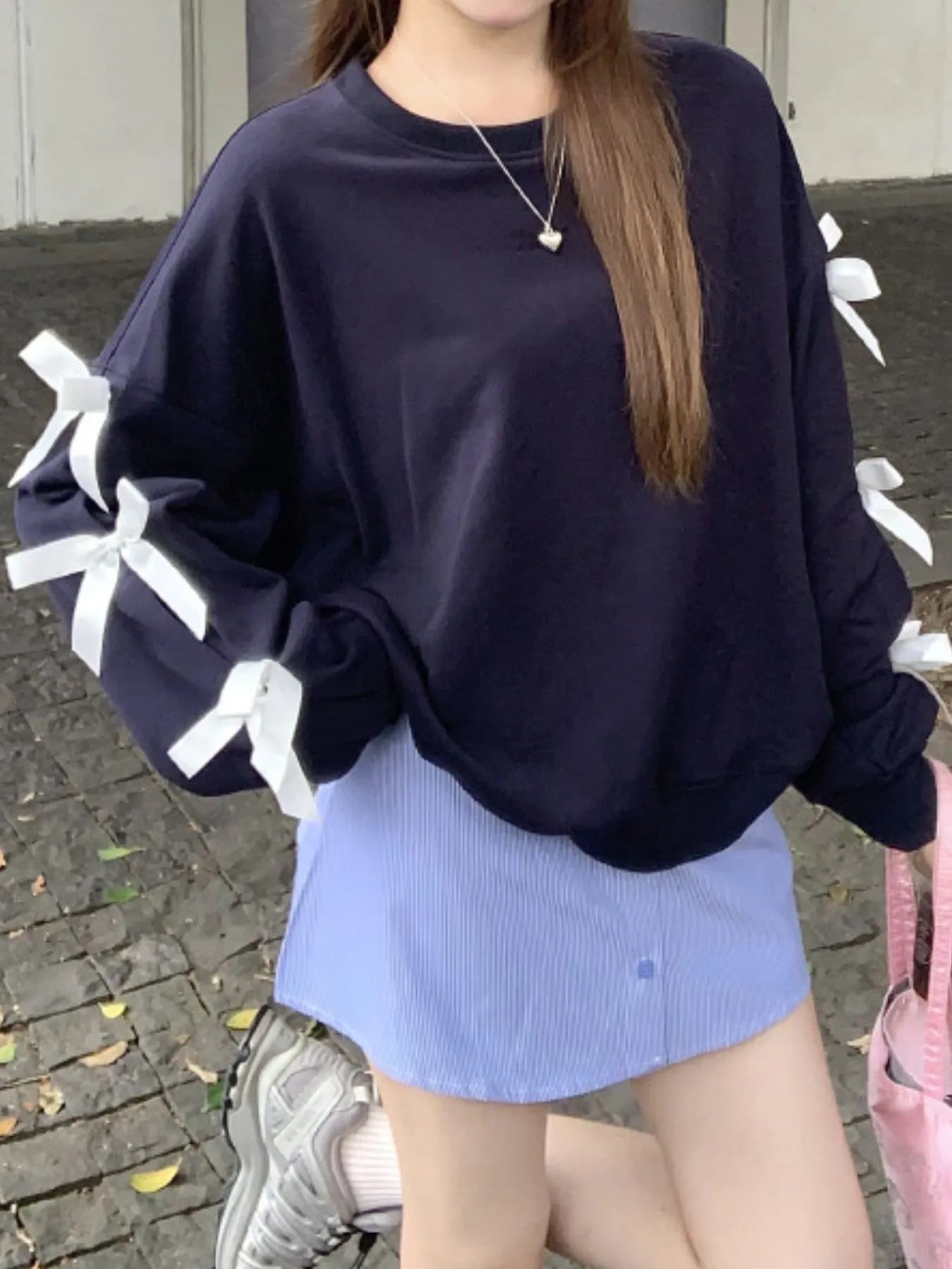 Dark blue round-neck sweatshirt with white ribbon bows on sleeves