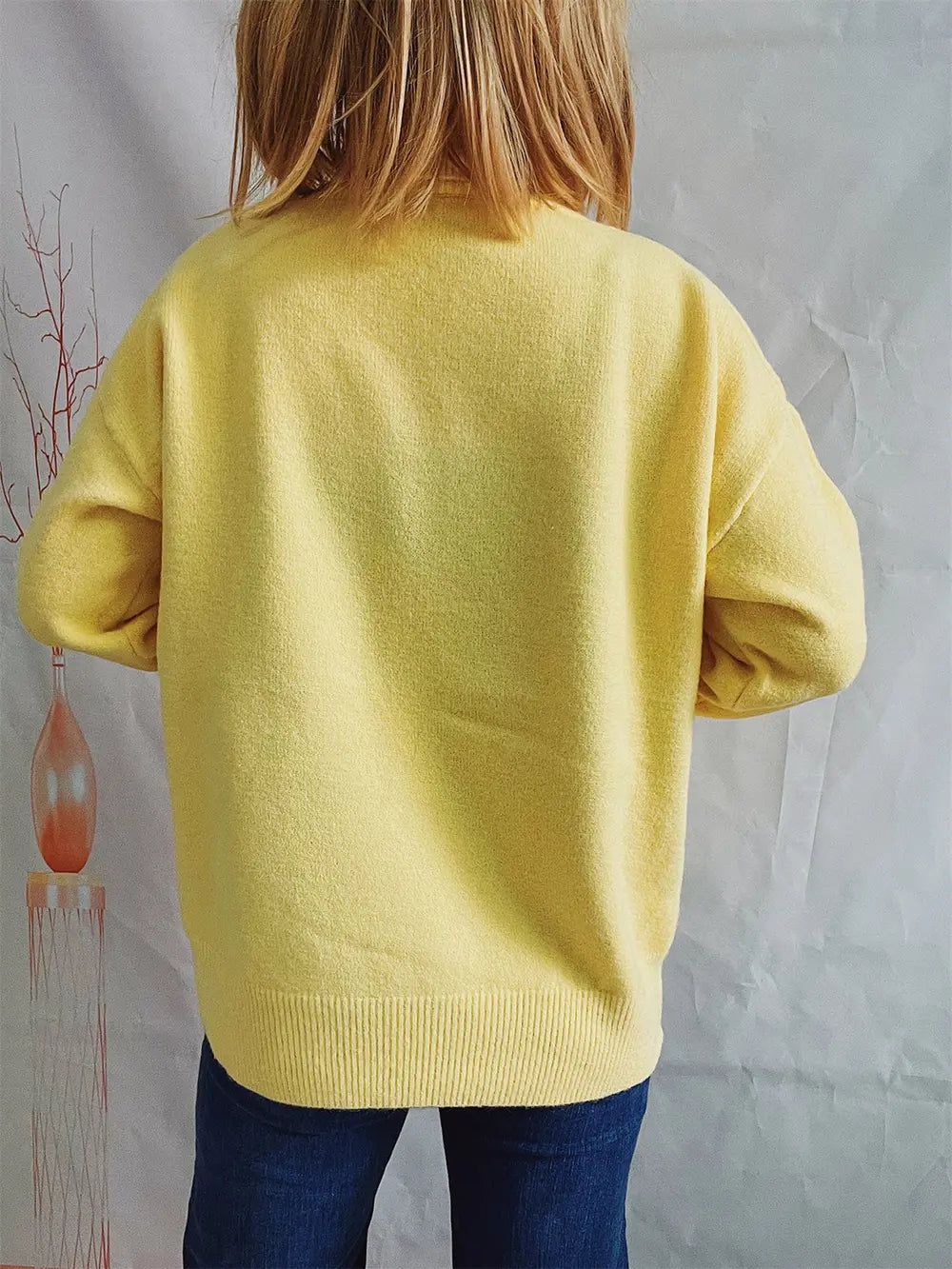 Yellow turtleneck long sleeve sweater with ribbed collar and hem, back view