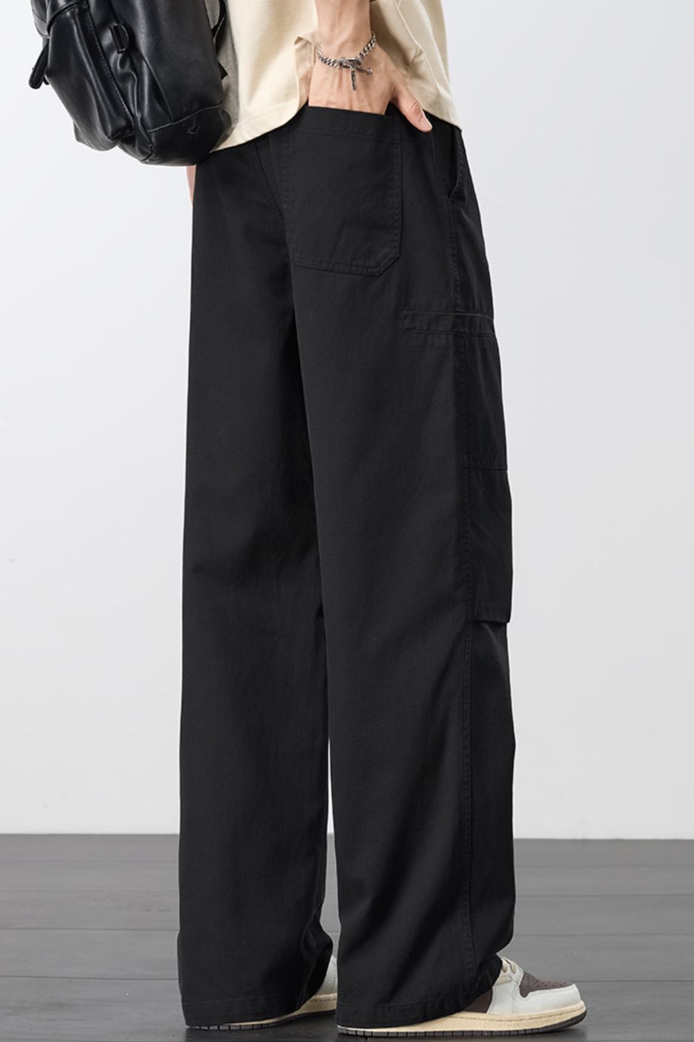 Black wide-leg cargo pants with drawstring waist and large side cargo pocket.