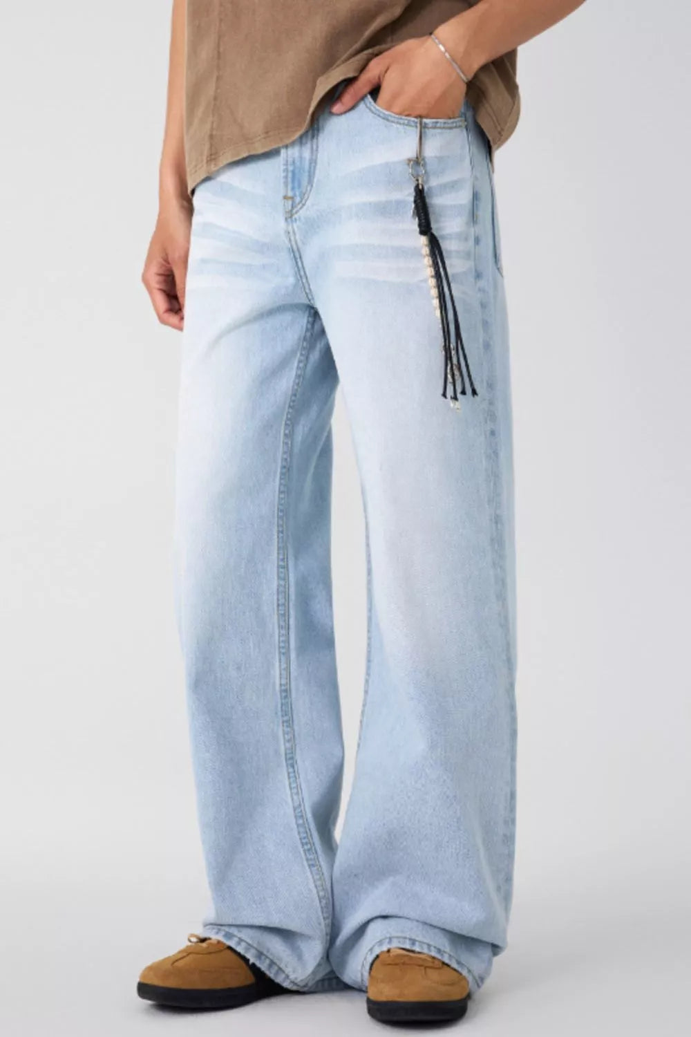 Wide-leg washed denim jeans in light blue, relaxed fit with hanging tassel cord