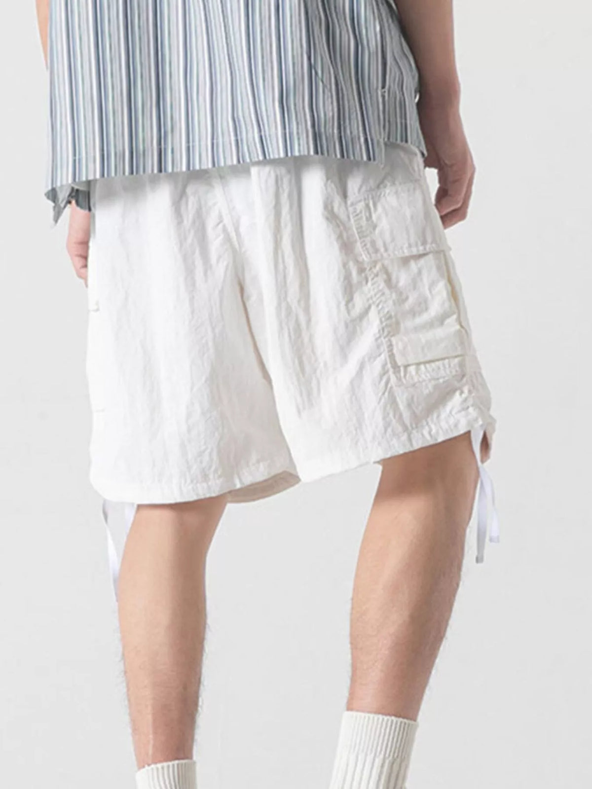 White cargo shorts with front flap pocket and drawstring hem ties