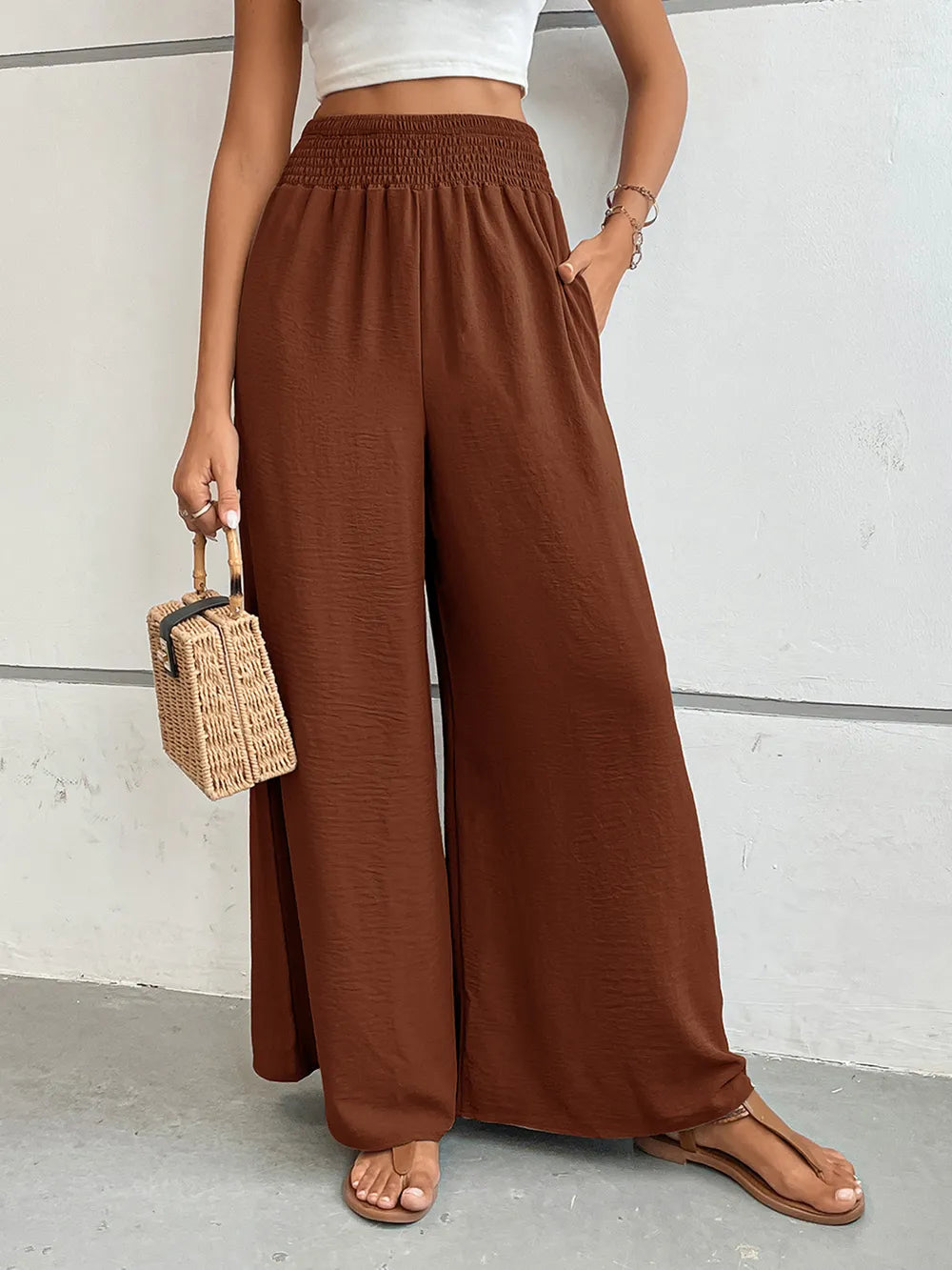 Wide-leg pants with pockets, dark brown textured fabric, high-rise elastic waistband.