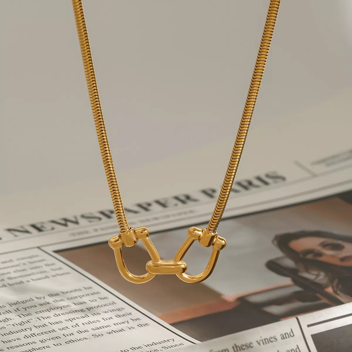 Gold-plated horseshoe pendant necklace with long rope chain and curved U-link centerpiece