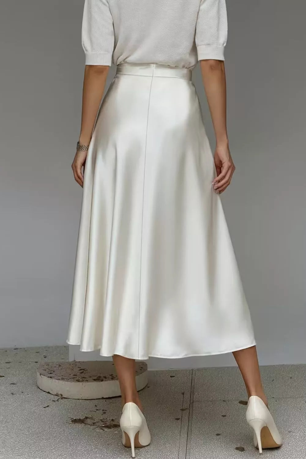 Cream satin A-line midi skirt with side pockets, smooth finish and mid-calf hem