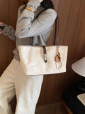 Beige suede medium tote bag with brown buckle strap and leather tassel charm