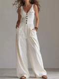 White sleeveless jumpsuit with button front, chest pockets, wide-leg silhouette