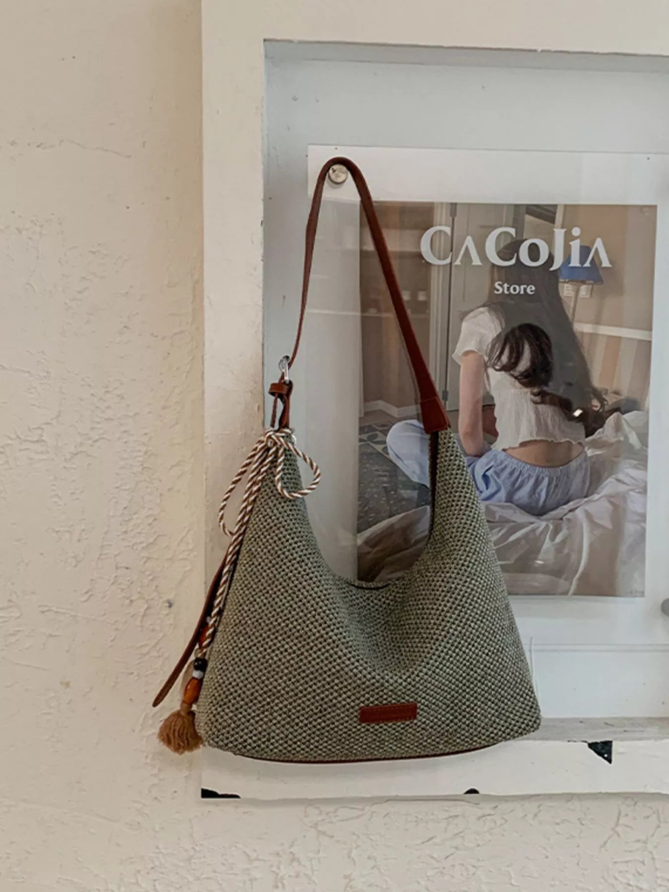 Medium woven shoulder bag with tassel fringe, open top, brown handles, textured gray
