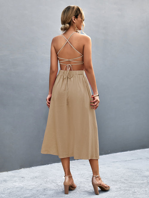 Back view: khaki button-front halter neck midi dress with crisscross straps.