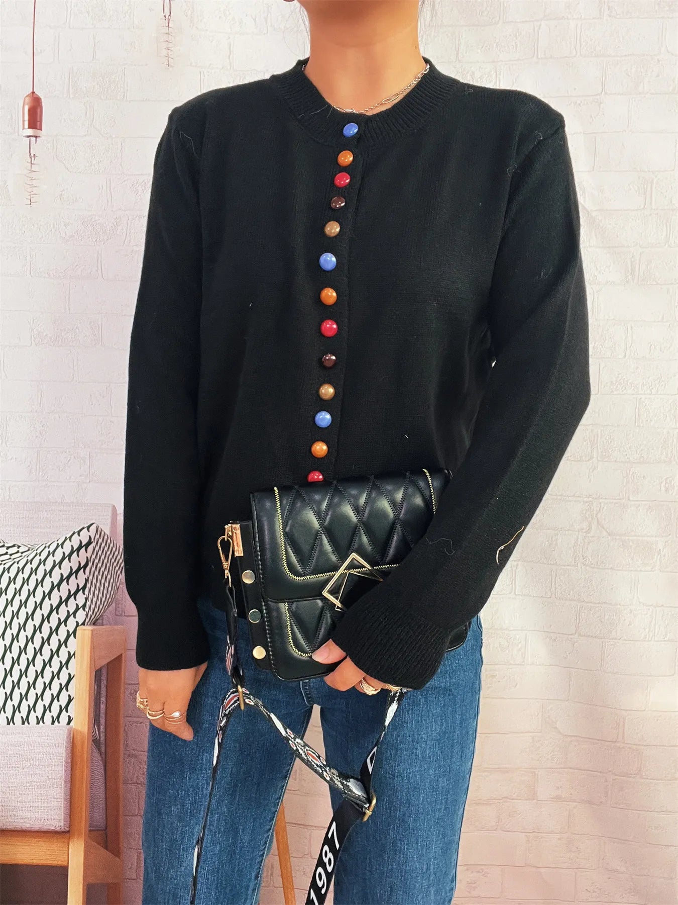 Black button-front cardigan with colorful detail buttons, crew neck, long sleeves