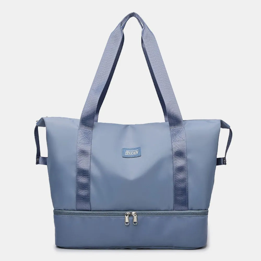 Light blue nylon travel duffel bag with double straps and zip-top front pocket.