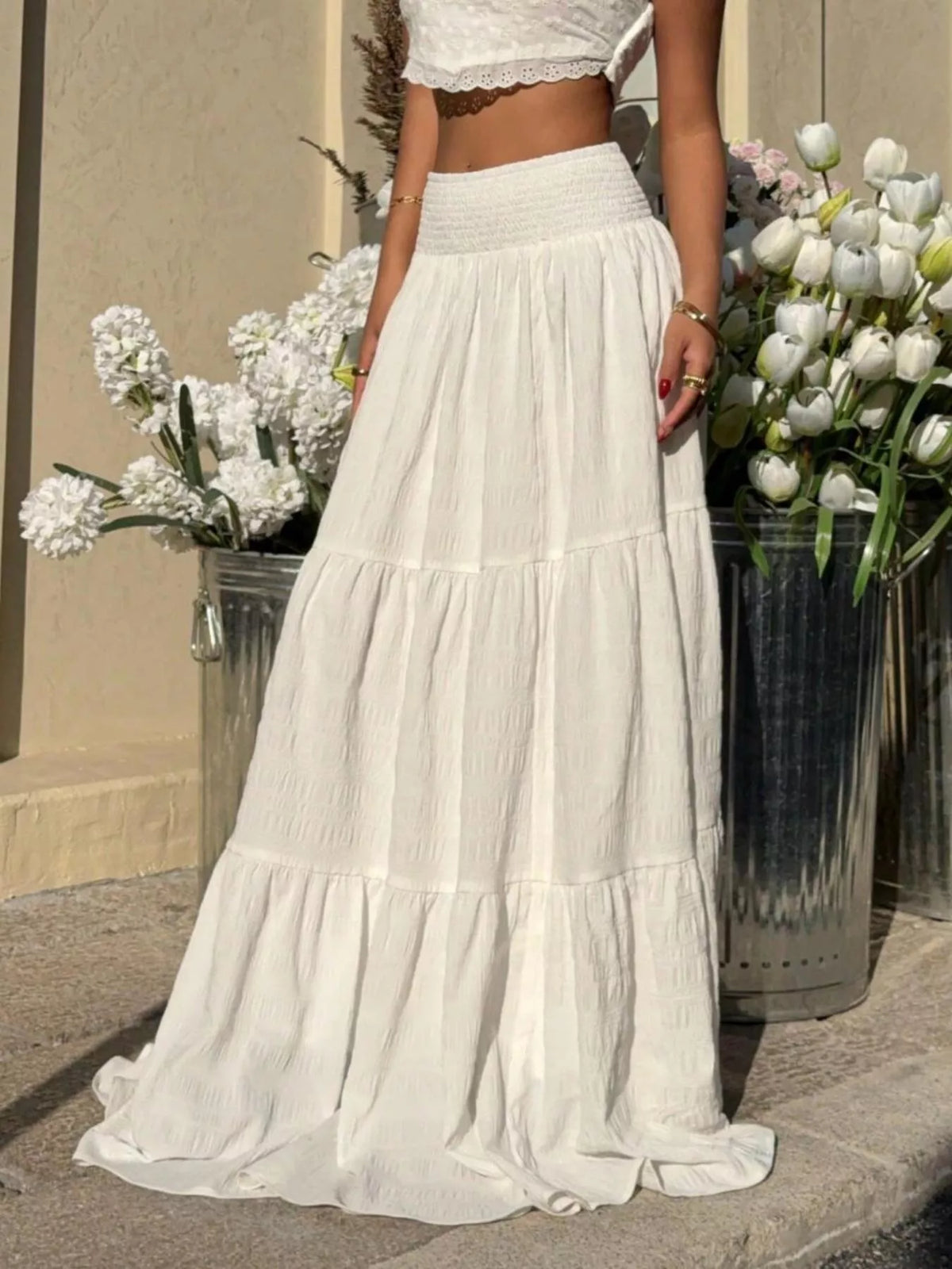 White tiered maxi skirt with elastic smocked waistband and ruffled tiers