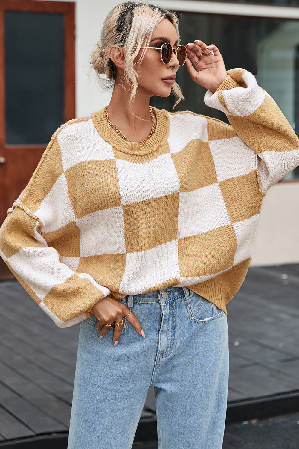 Tan and white checkered sweater with ribbed crew neck, drop shoulders, and long sleeves