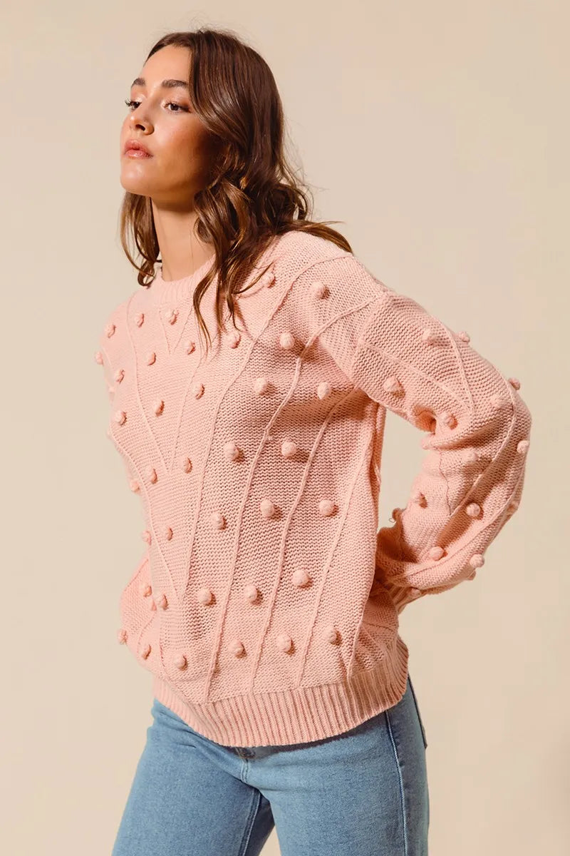 Blush textured knit crewneck sweater with raised pom-pom details and long sleeves