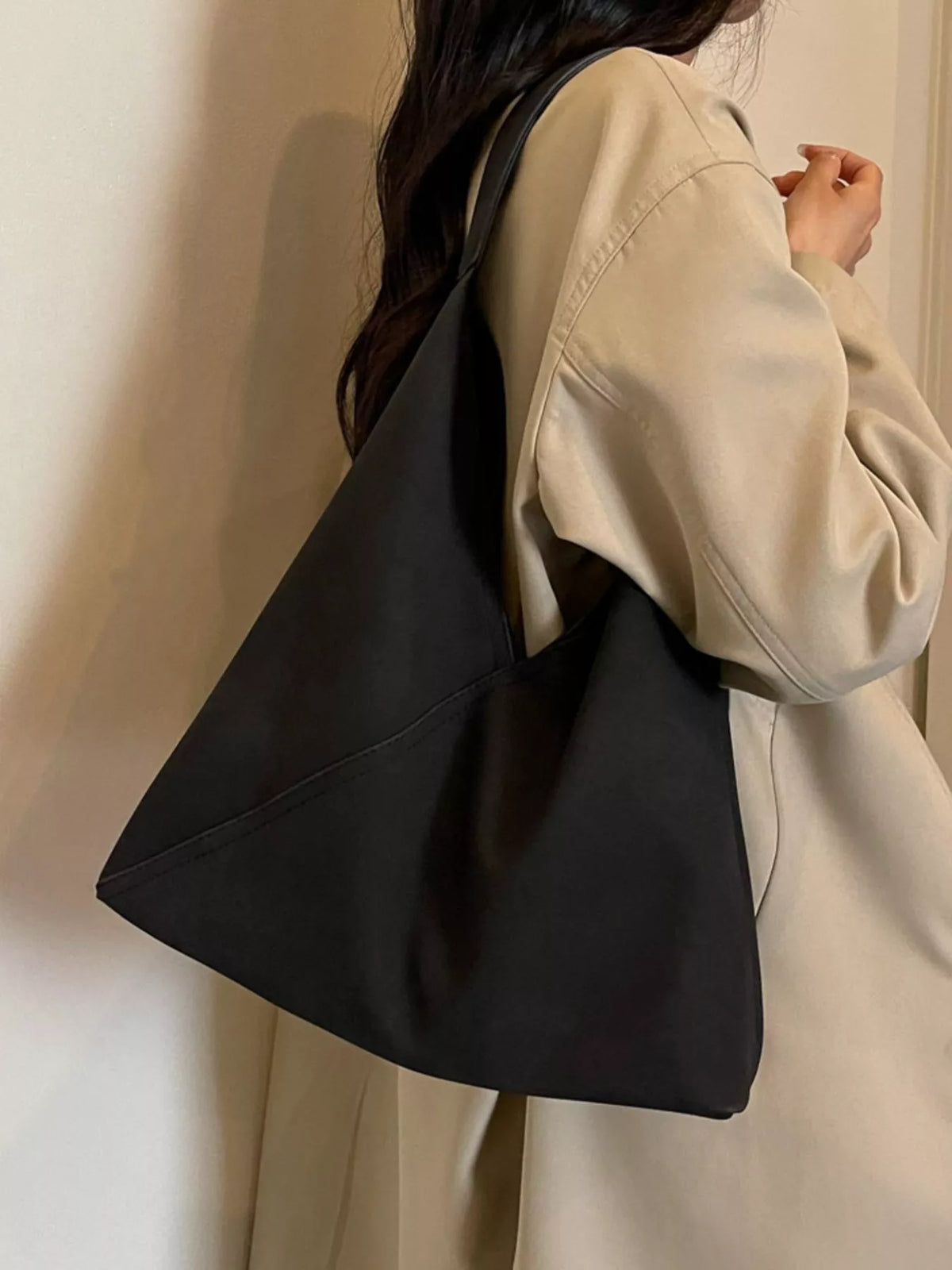 Black slouchy suede shoulder bag with open top and wide shoulder strap