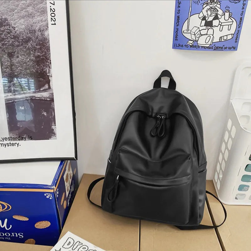 Black vegan leather zip backpack with side straps and top drawstring cord