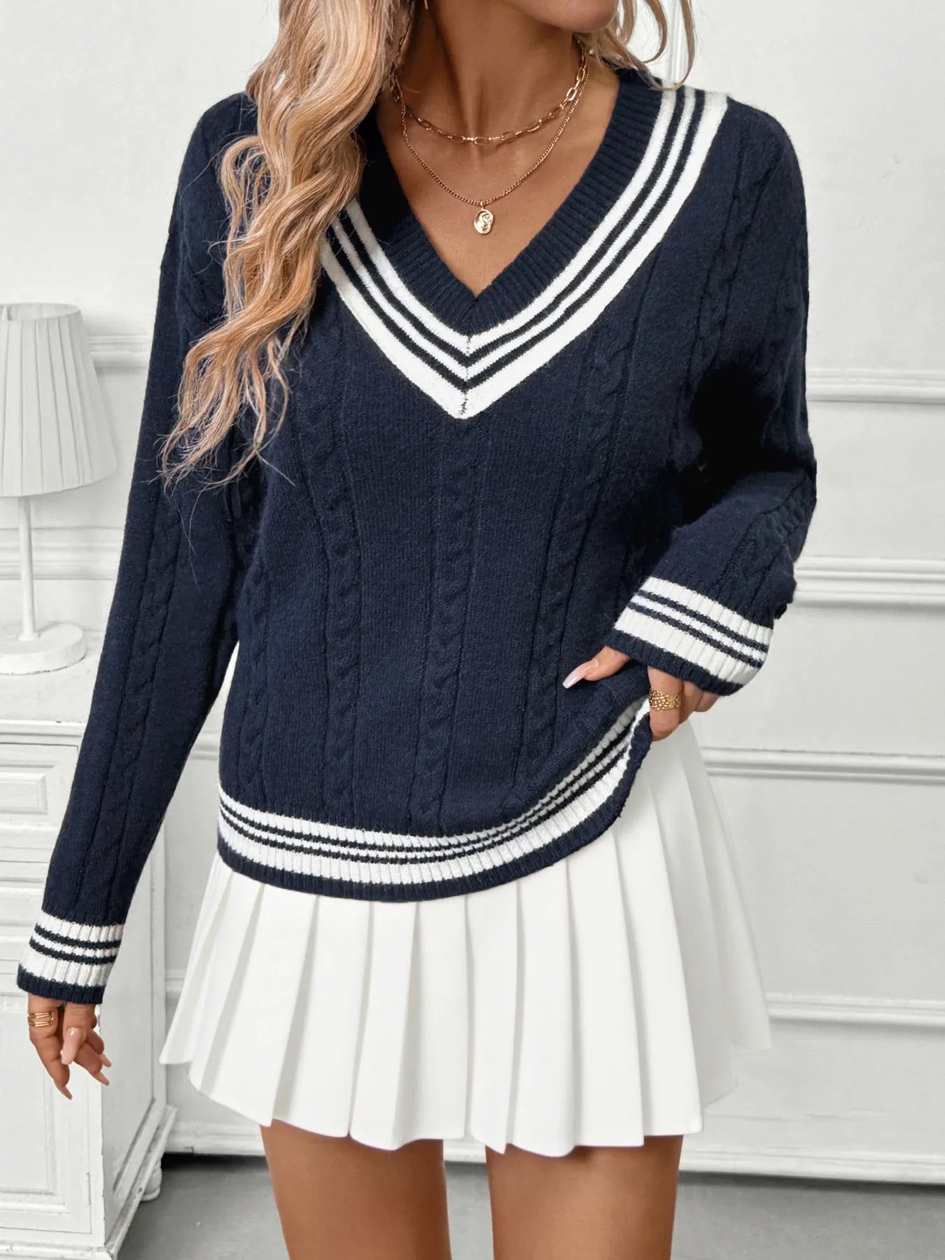 Dark blue V-neck sweater with contrast striped cuffs and cable knit pattern