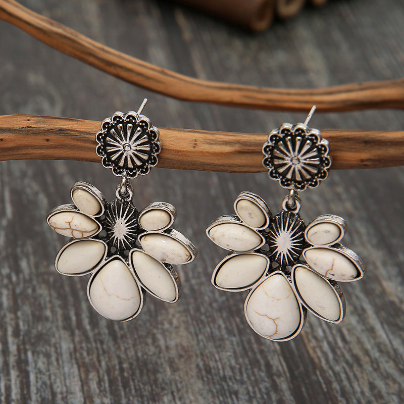 White flower earrings with oval white petals and silver-tone filigree sunburst tops.