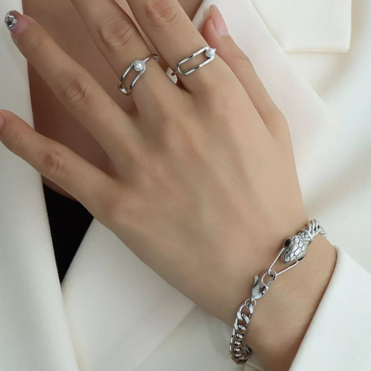 Silver snake-motif chain bracelet with textured charm on wrist