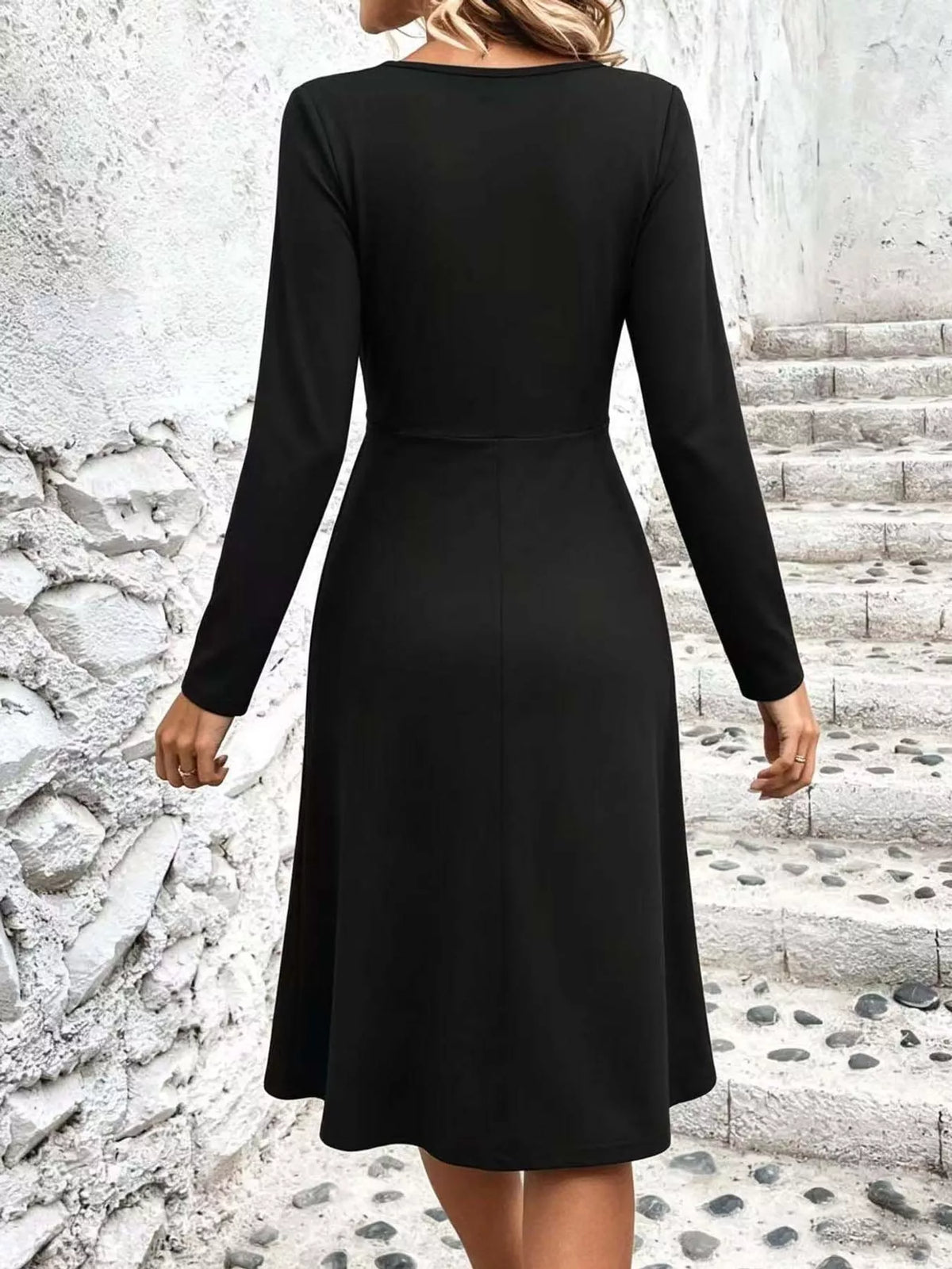 Black long-sleeve midi dress back view with smooth skirt and waist shaping seam