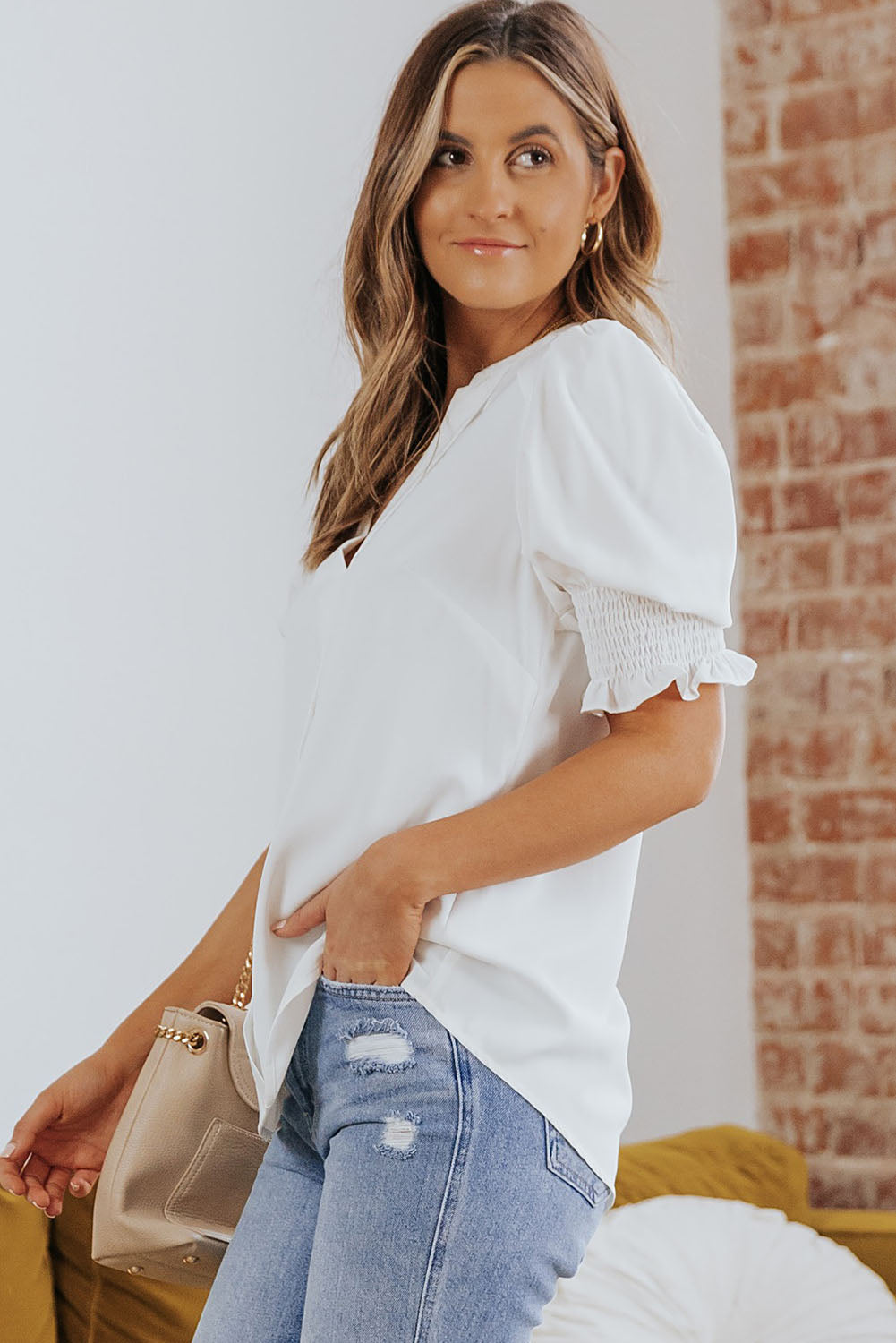 White blouse side view with smocked flounce cuff and puff sleeve, notched V-neck