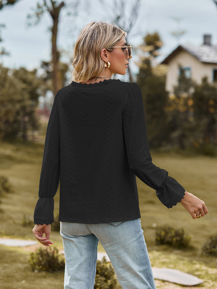 V-neck flounce-sleeve blouse in dark color, back view with long ruffled cuffs