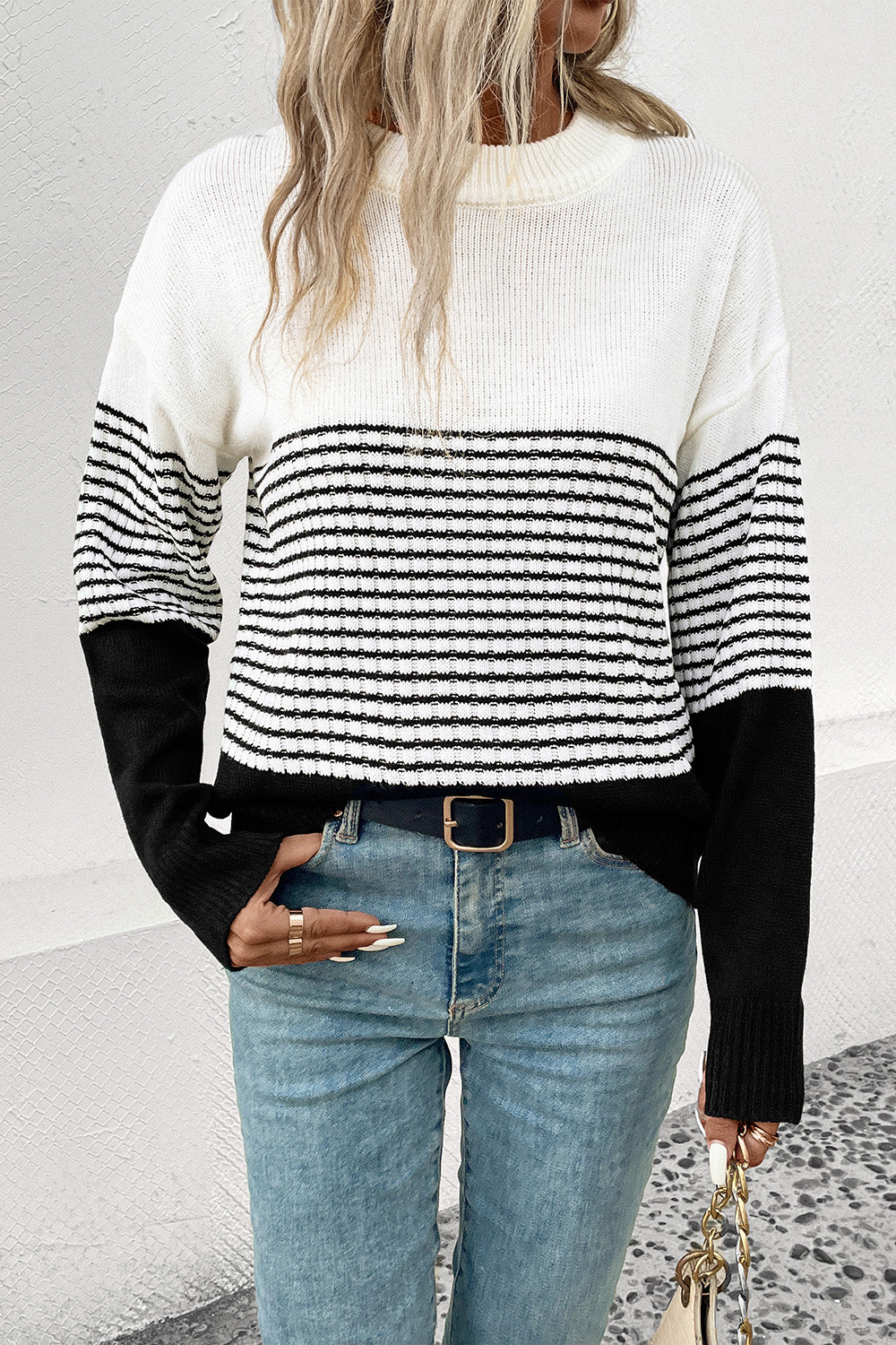 Striped drop-shoulder sweater in white with black horizontal bands, ribbed cuffs and hem
