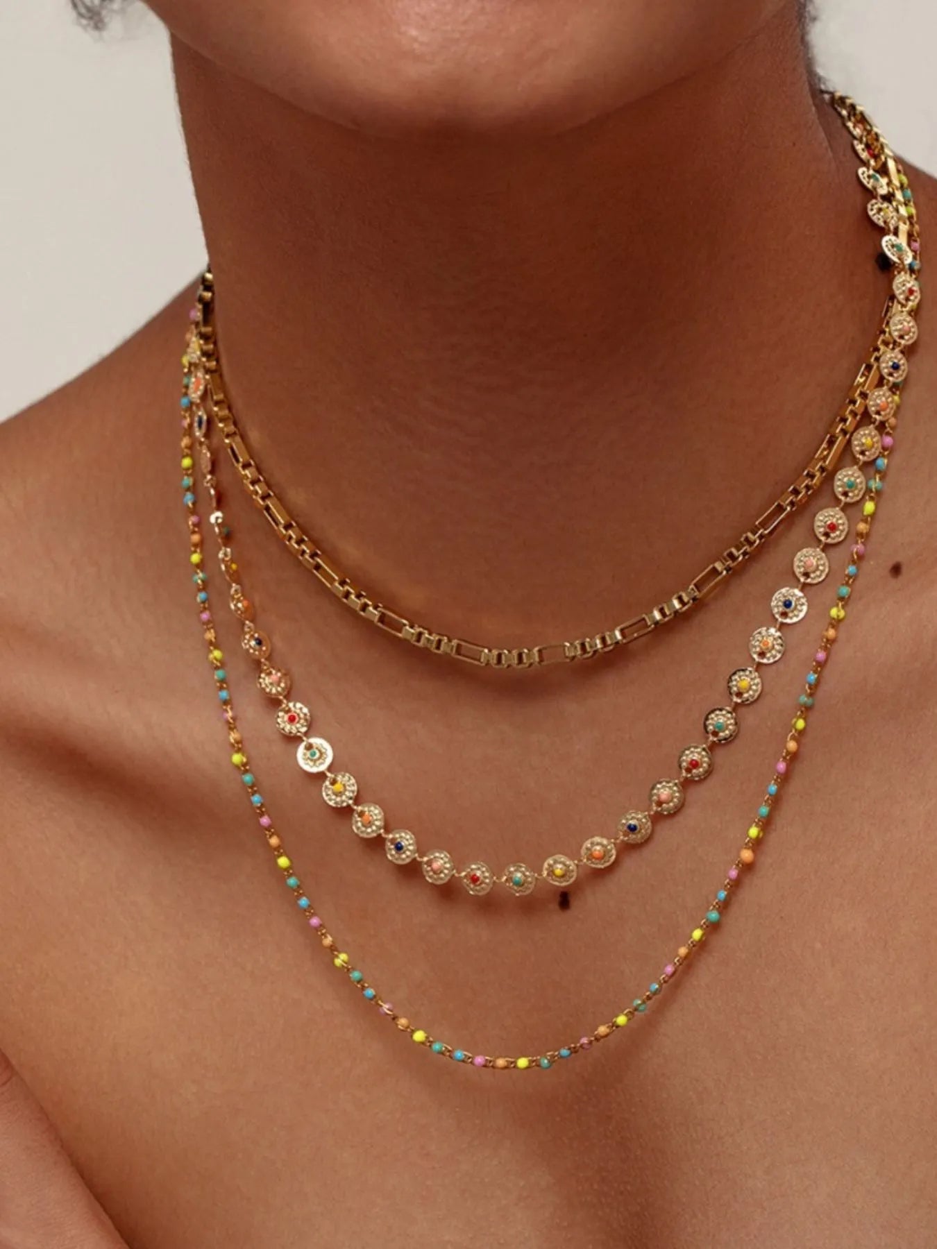 Gold-plated layered resin bead necklace with multicolor bead drops and oval charms