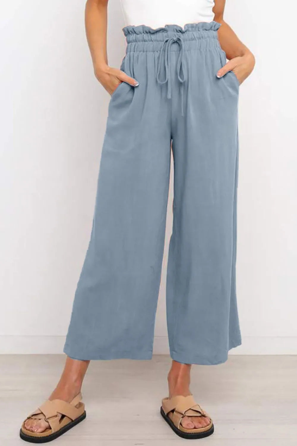 Blue wide-leg drawstring pants with paperbag-style waist, loose fit through thighs