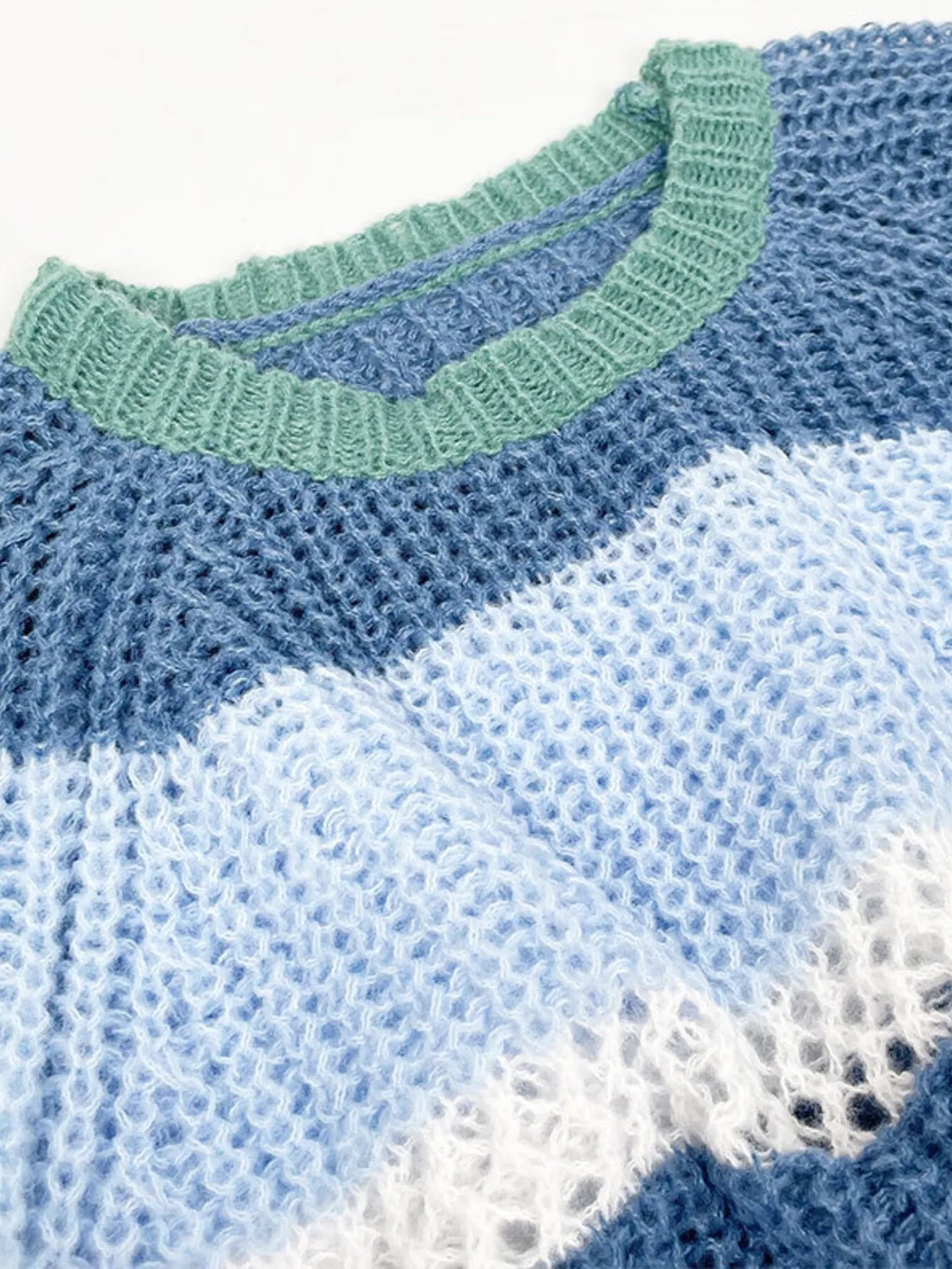 Openwork knit striped crop sweater close-up with ribbed neckline and wavy texture
