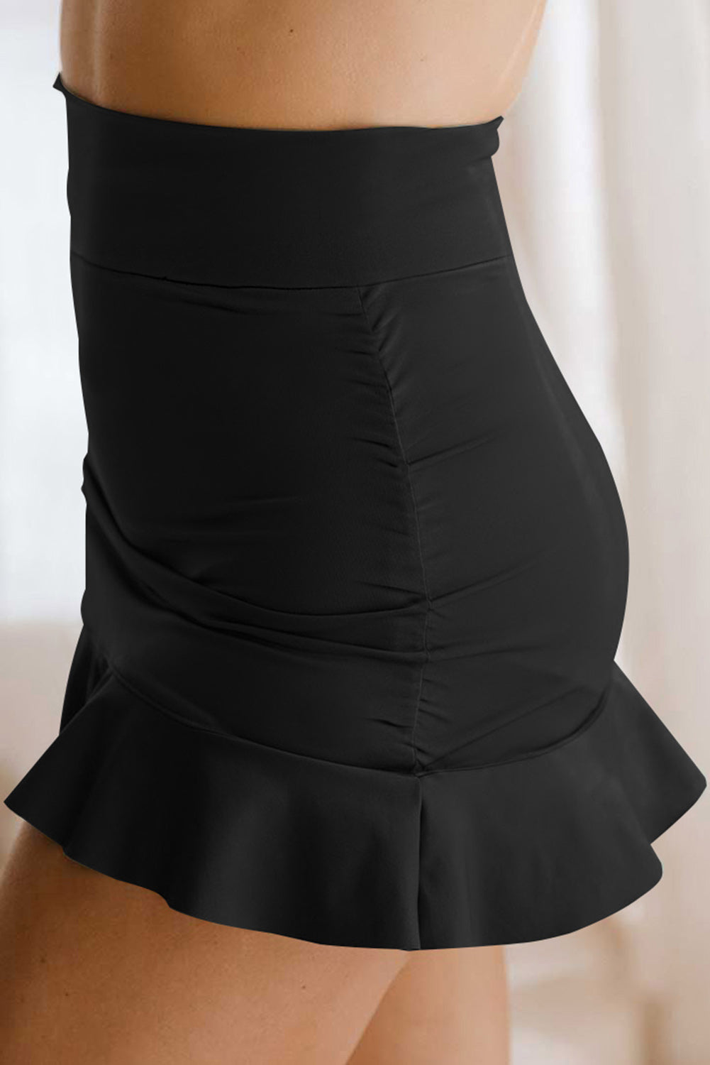 Black swim skort with gathered back and layered ruffle hem