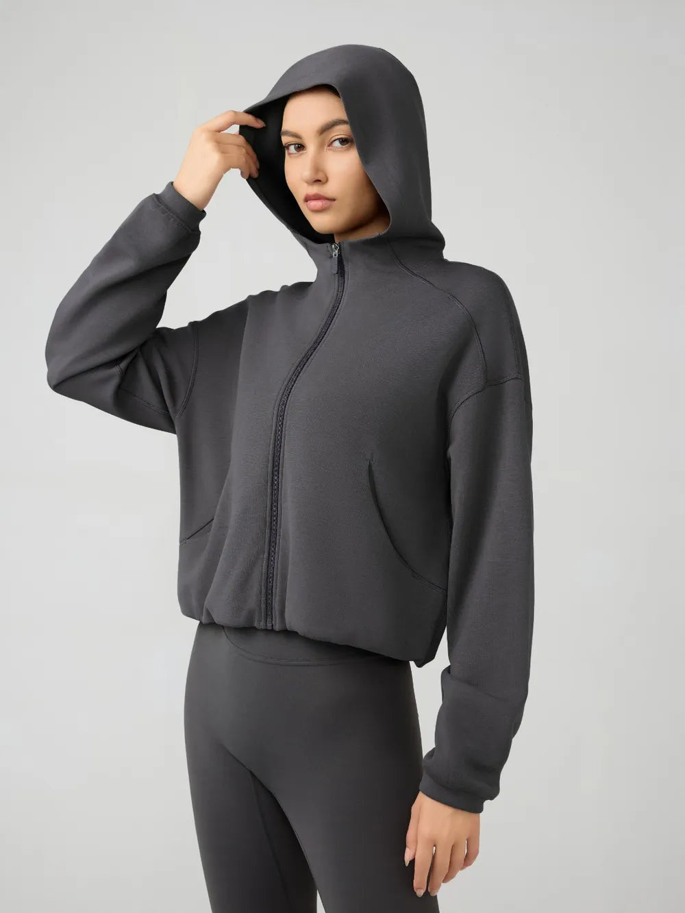 Dark gray hooded active zip jacket with long sleeves and relaxed dropped-shoulder fit