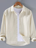 Light cream button-up long sleeve shirt with pointed collar and front button placket.