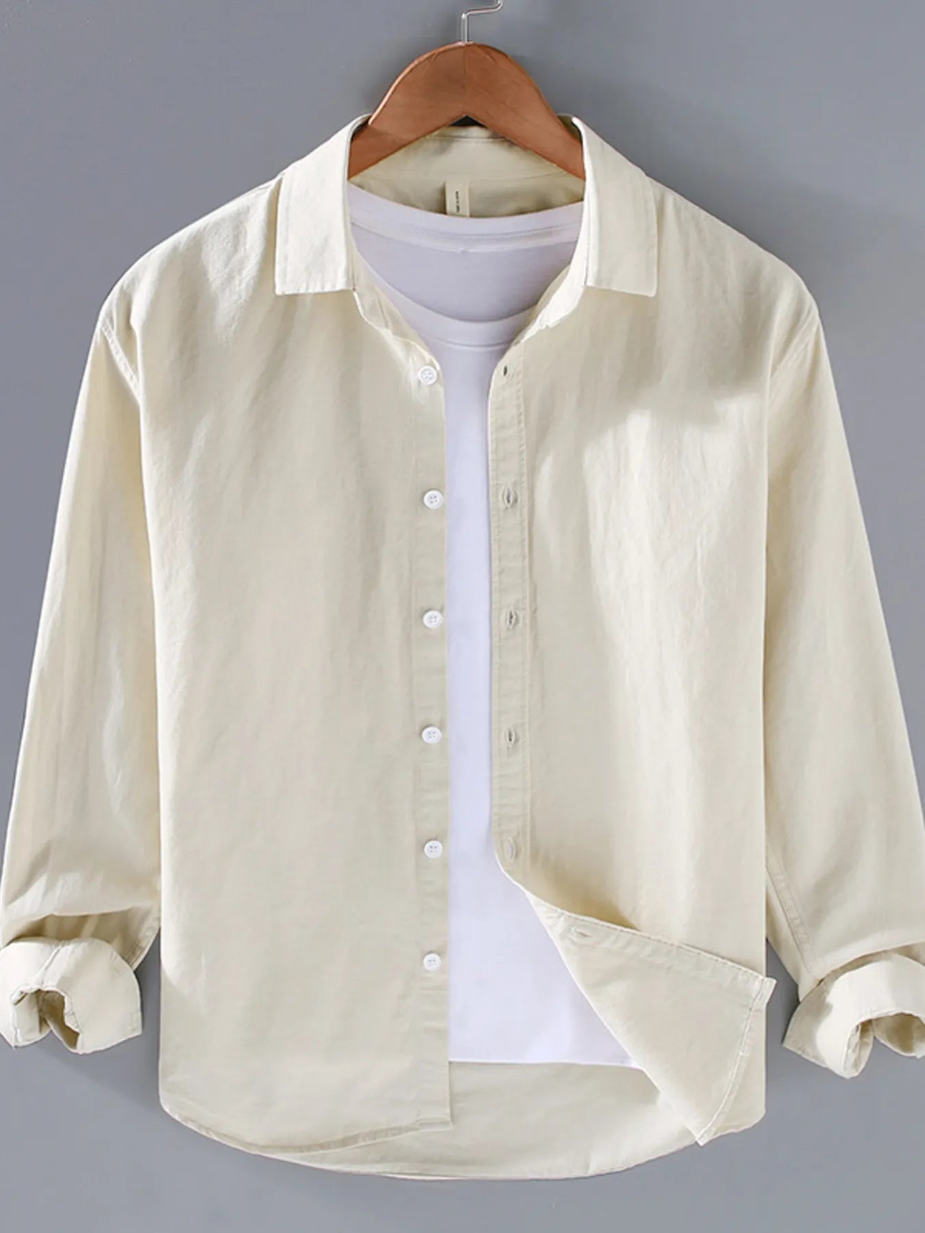 Light cream button-up long sleeve shirt with pointed collar and front button placket.