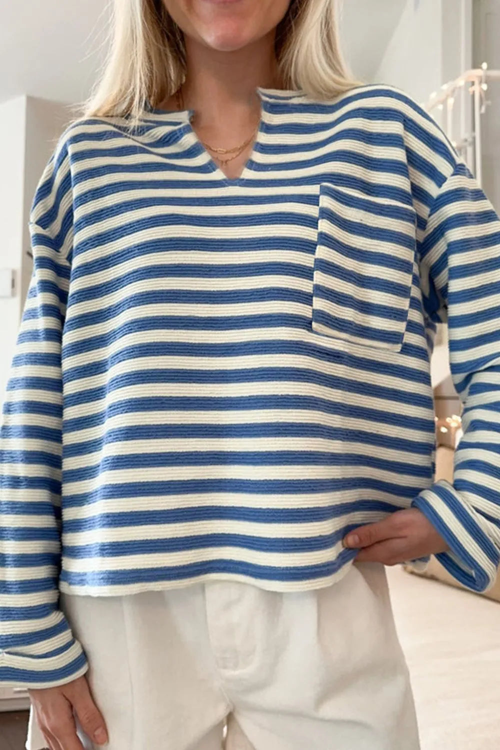 Blue and white striped long-sleeve top with chest pocket and V-neck