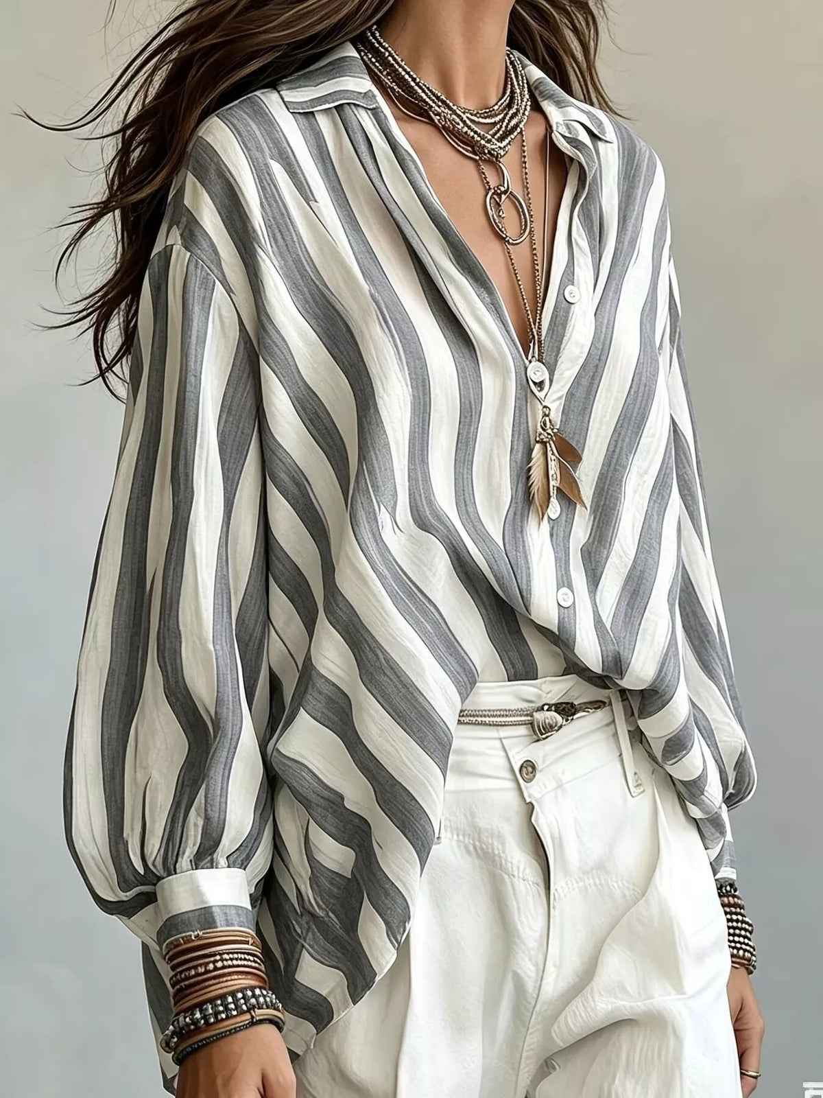 White and dark gray striped loose-fit button down shirt with long sleeves and buttons