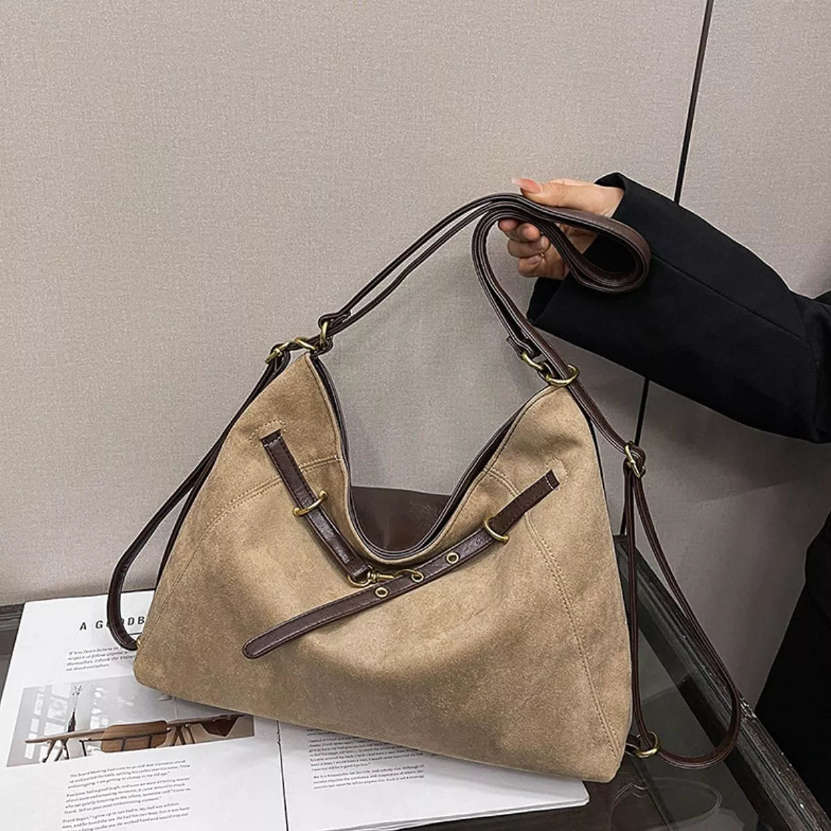 Tan suede shoulder bag with decorative buckle, side angle view with double straps