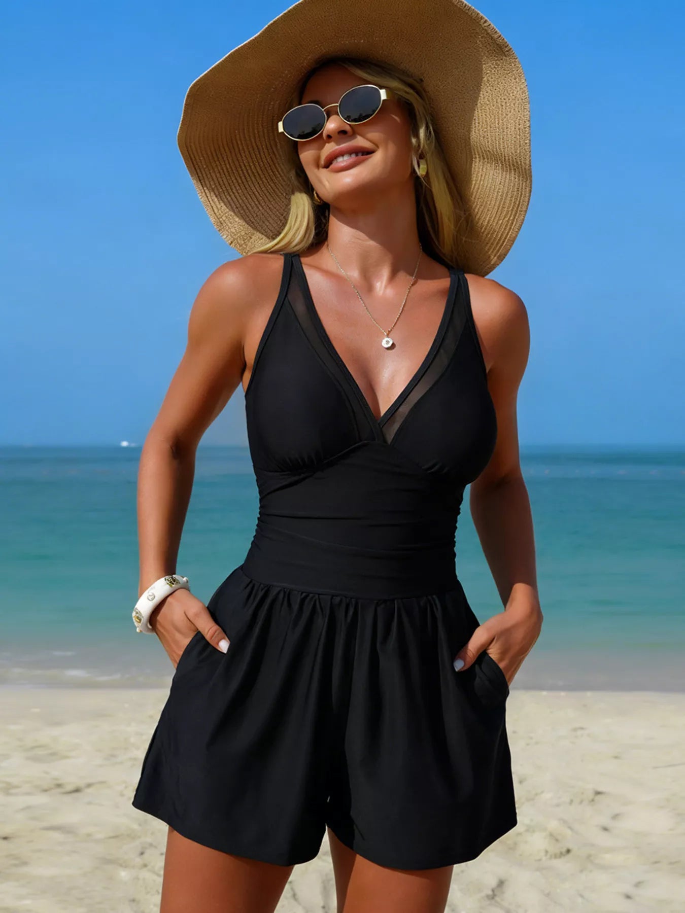 V-Neck One-Piece Swimsuit with Pockets in black worn by woman at the beach