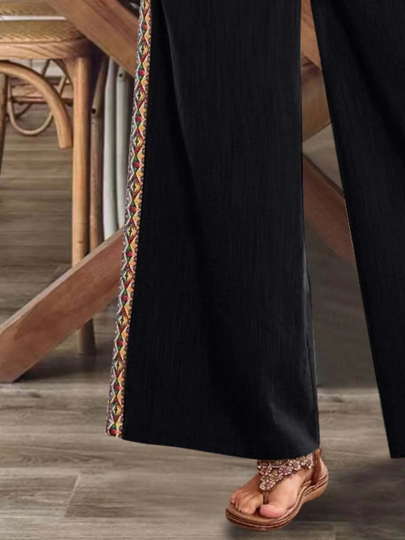 Black wide-leg pants with embroidered side stripe and flowing drape hem